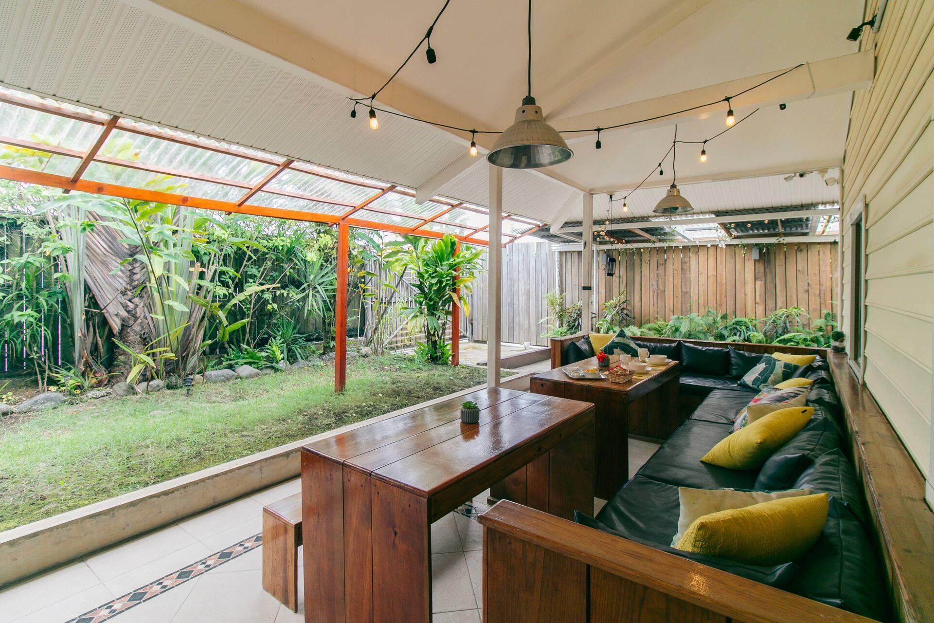 The covered timber lounge at Pineapple House, opening onto a planted garden