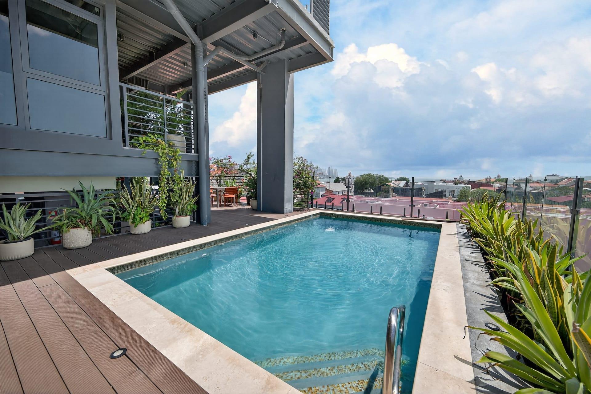 The saltwater rooftop pool with a timber deck and city views