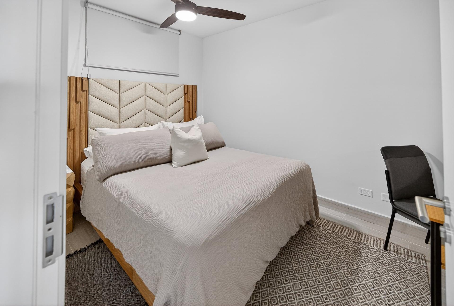 The bedroom with a queen bed and a panelled headboard