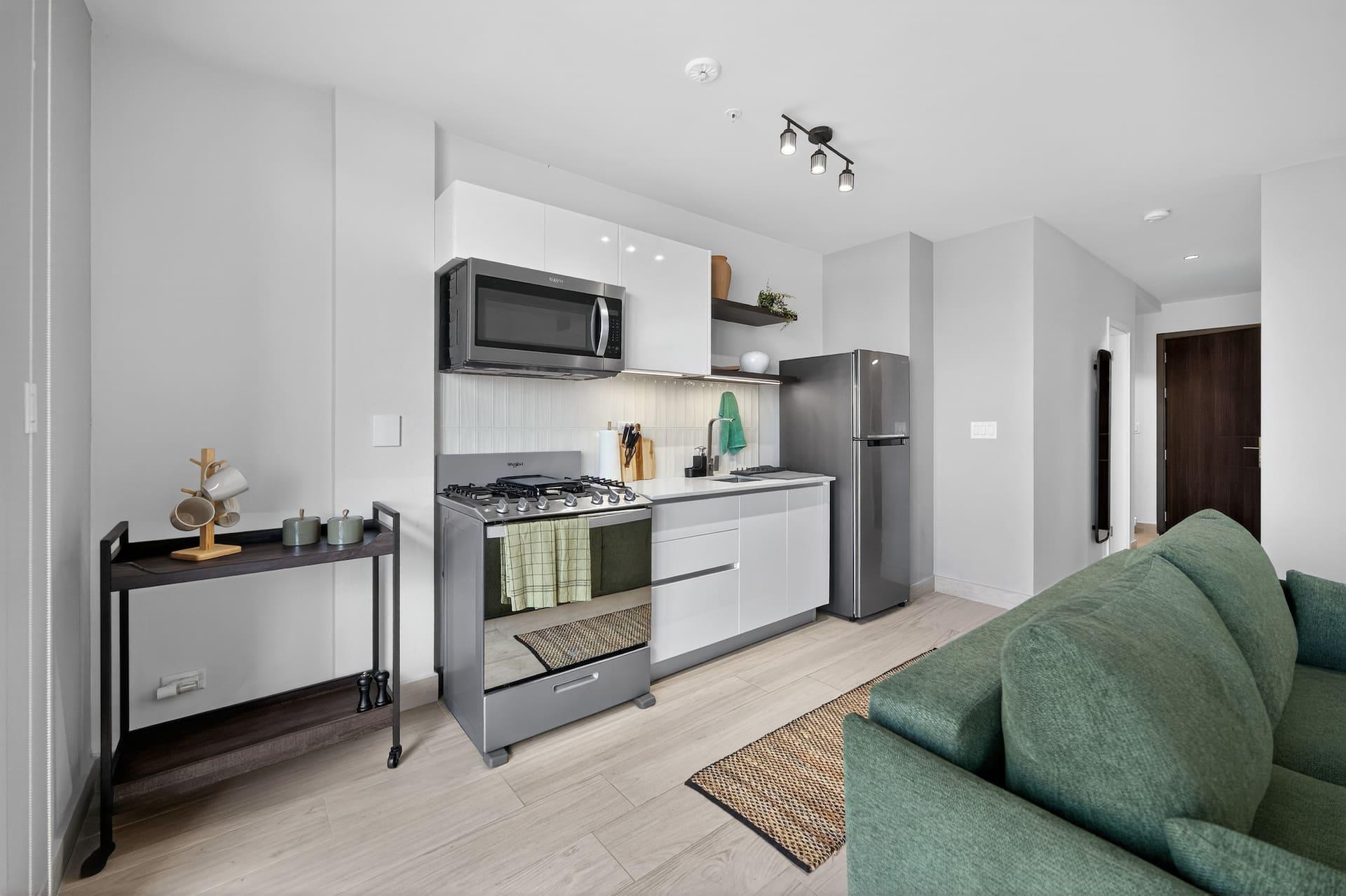 The kitchen with a gas hob, oven and full size fridge