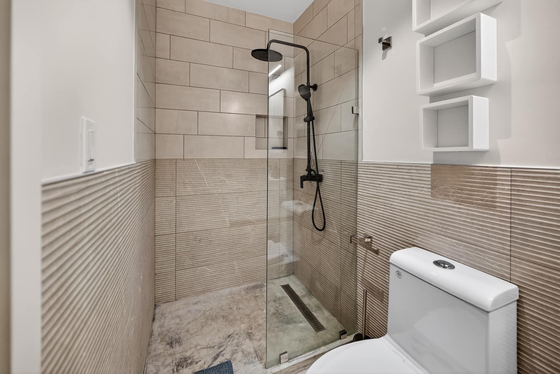 The bathroom with a glass walk in shower